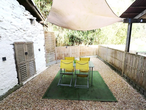 Outdoor patio with chairs and shade canopy.