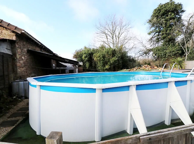 Above-ground swimming pool in a garden setting.