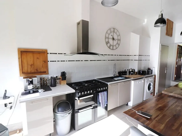 Modern kitchen with appliances and wooden table.