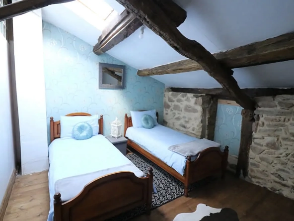 Rustic bedroom with twin beds and wooden beams.