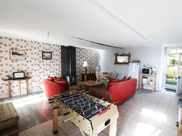 Cosy living room with foosball, sofas, and dining area.
