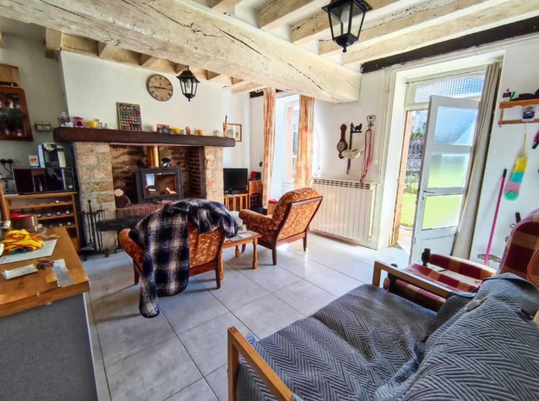 Cosy living room with fireplace and wooden beams.