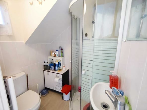 Compact bathroom with shower and toilet.