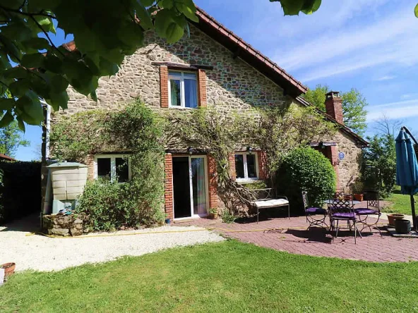 Stone cottage with garden and outdoor seating.