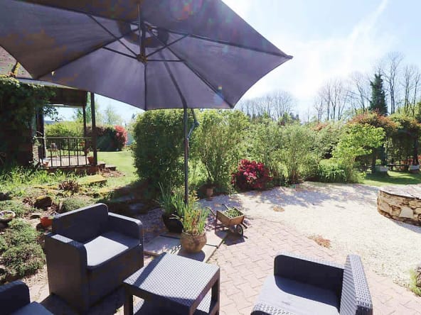 Outdoor garden with patio seating and umbrella.