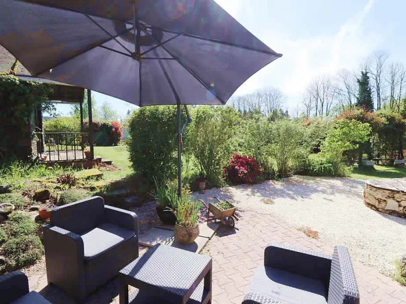 Outdoor garden with patio seating and umbrella.