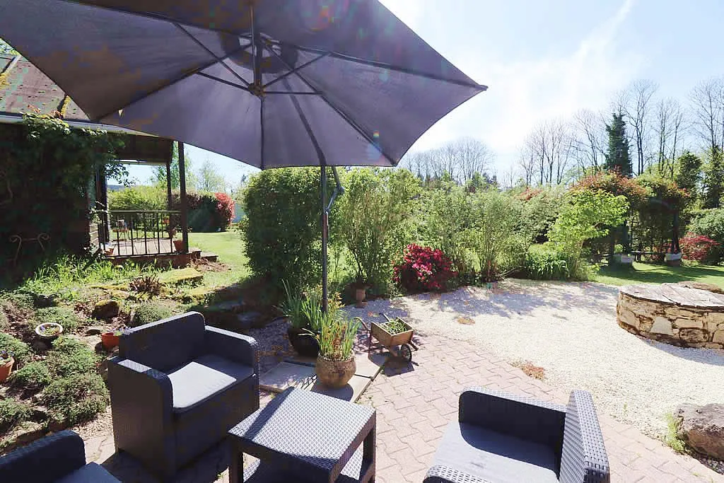 Outdoor garden with patio seating and umbrella.