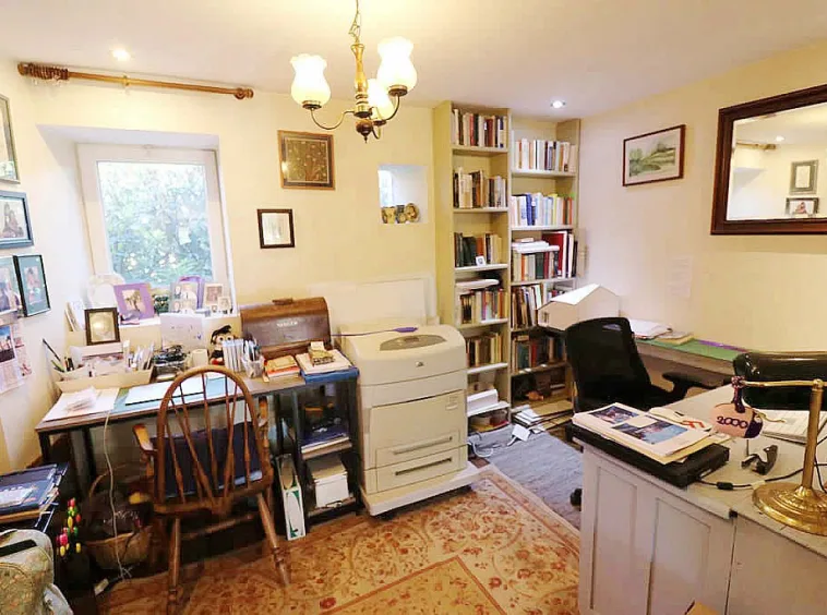 Home office with desk, chair, and bookshelf.
