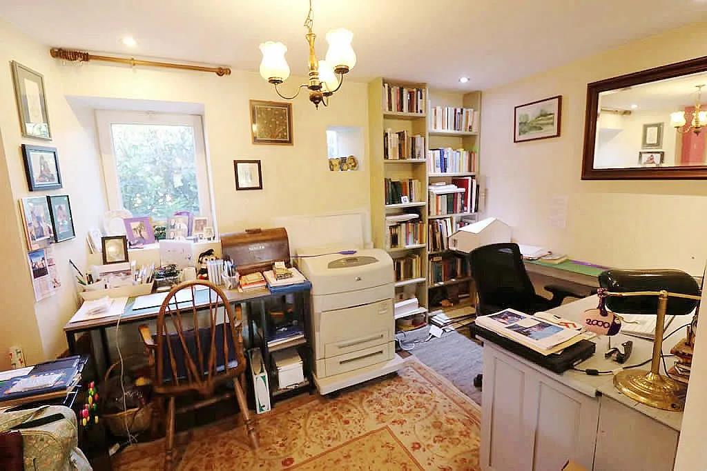 Home office with desk, chair, and bookshelf.