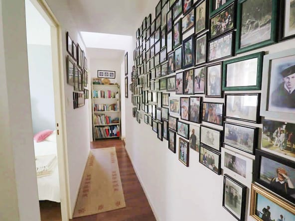Hallway with photo wall and bookcase.