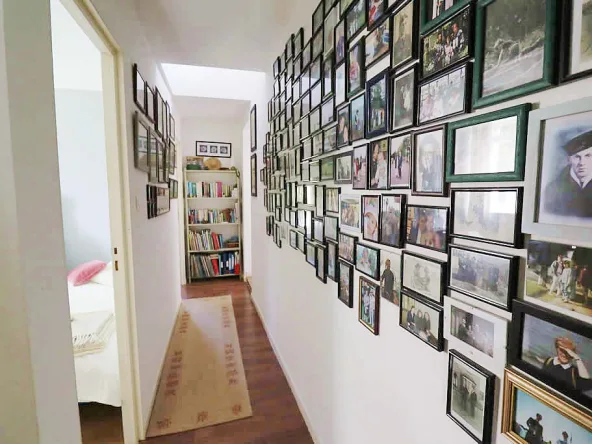 Hallway with photo wall and bookcase.