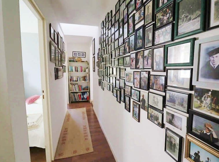 Hallway with photo wall and bookcase.