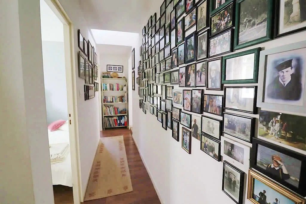 Hallway with photo wall and bookcase.