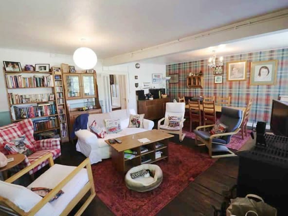 Cosy living room with bookshelves and dining table.
