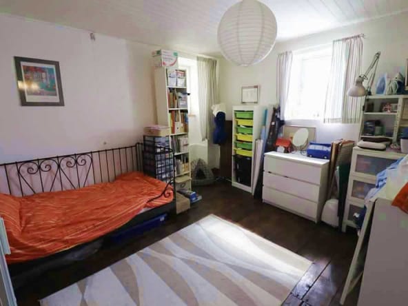 Cosy bedroom with bed, shelves, and natural light.