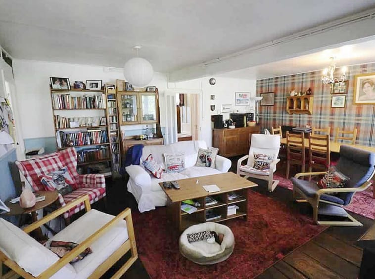 Cosy living room with bookshelves and seating area.