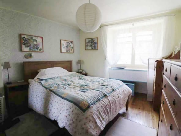 Cosy bedroom with double bed and wooden furniture.