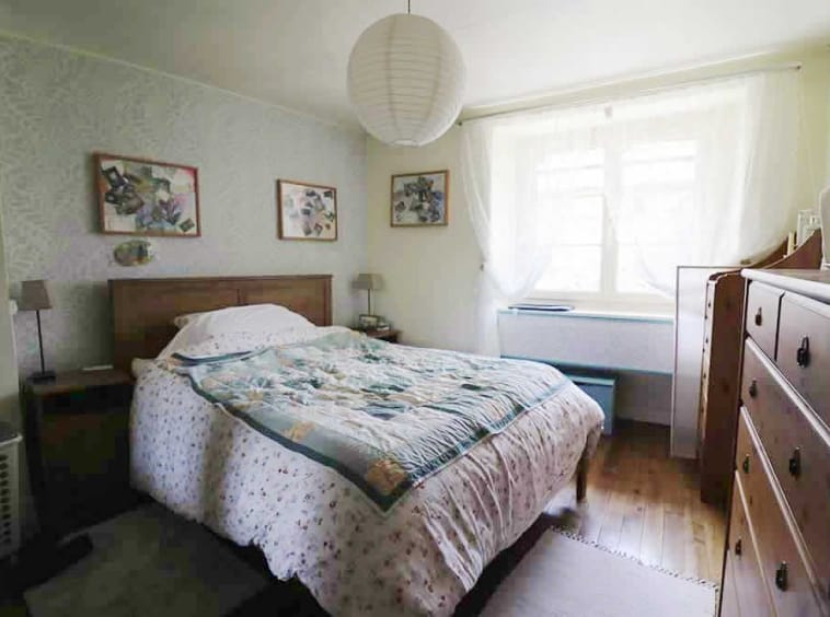 Cosy bedroom with double bed and wooden furniture.
