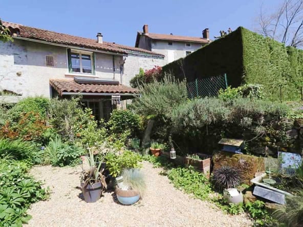 Cottage garden with lush greenery and pebble path.