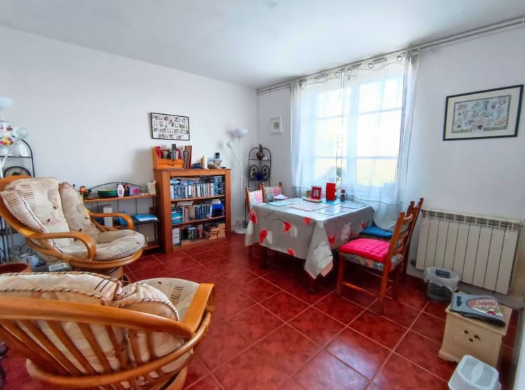 Cosy living room with chairs and bookshelves.