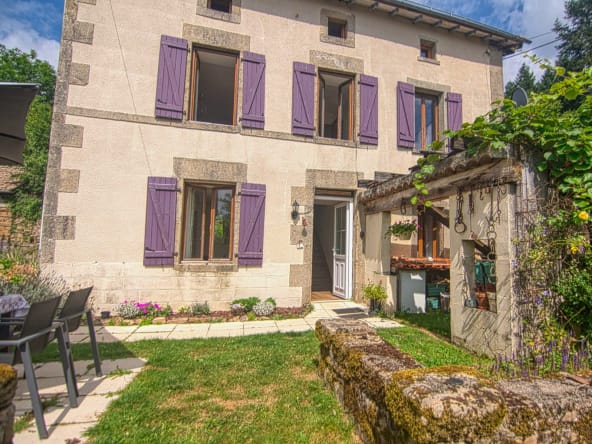 Charming house with purple shutters and garden.