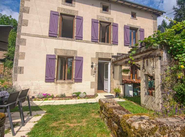 Charming house with purple shutters and garden.