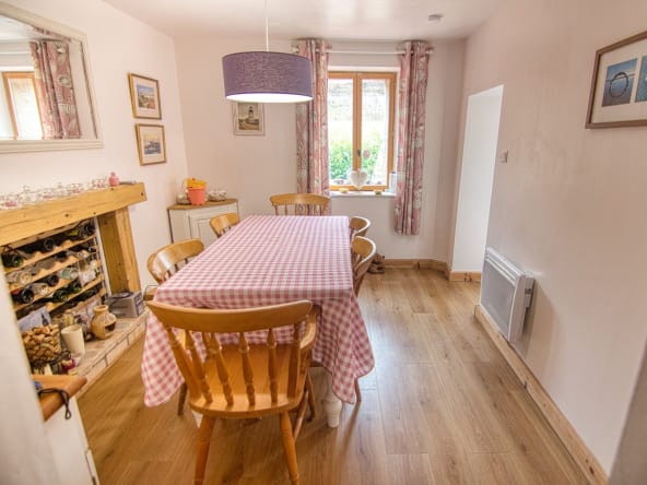 Cosy dining room with wooden furniture and checked tablecloth.