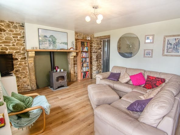 Cosy living room with stone fireplace and sofas.