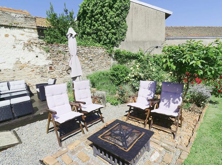 Garden patio with chairs and a fire pit
