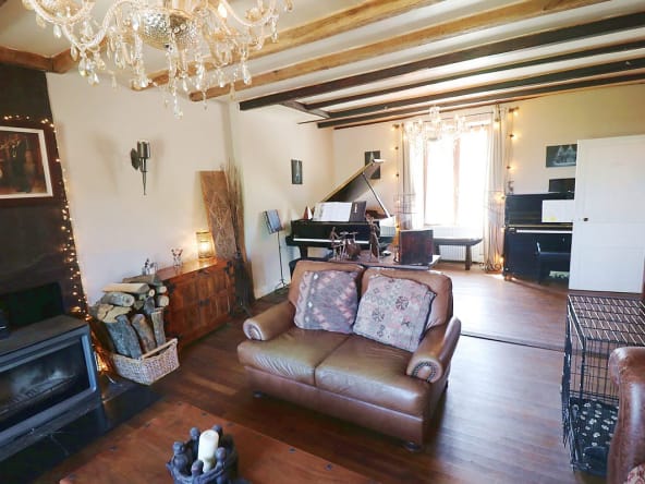 Cosy living room with piano and fireplace.