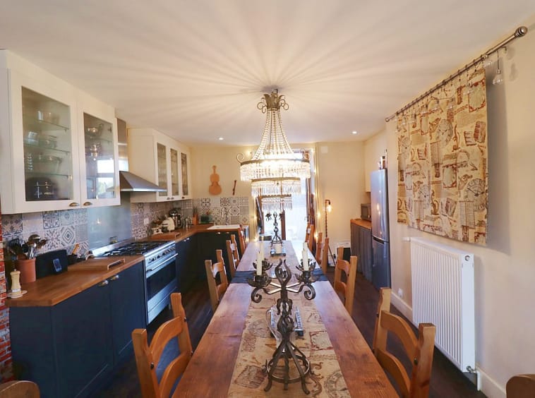 Elegant kitchen with chandelier lighting and dining setup.