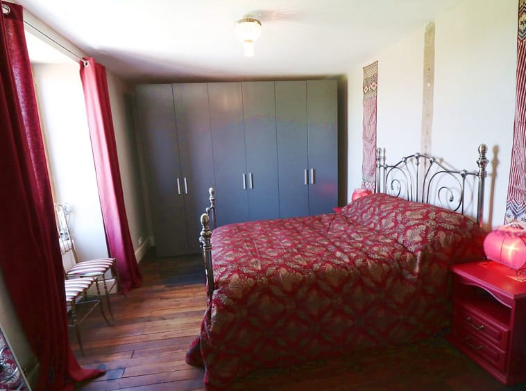 Bedroom with red decor and grey wardrobe