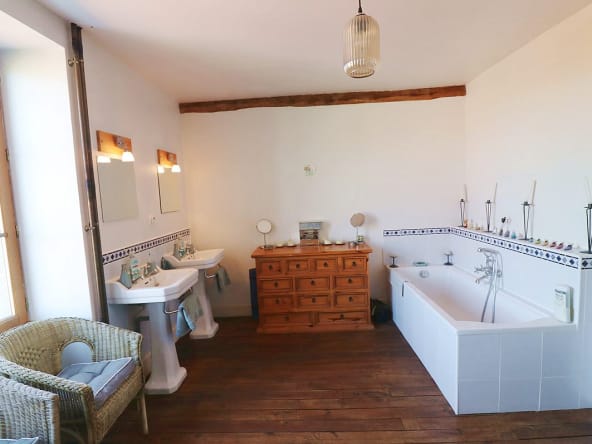 Spacious bathroom with double sinks and bathtub.