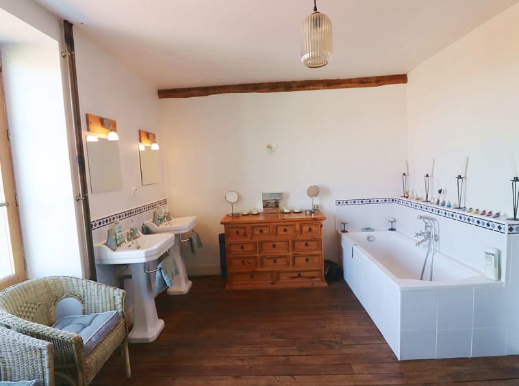 Spacious bathroom with double sinks and bathtub.