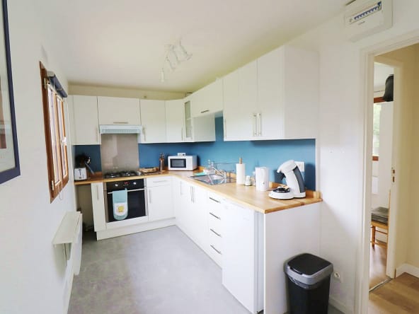 Cuisine moderne avec des armoires blanches et des accents bleus.