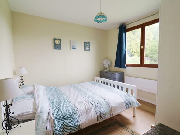 Chambre confortable avec lumière naturelle et décor.