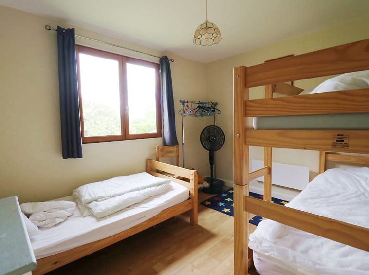 Chambre simple avec lit superposé et lit simple.