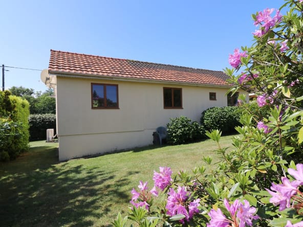 Maison de plain-pied avec jardin et fleurs roses