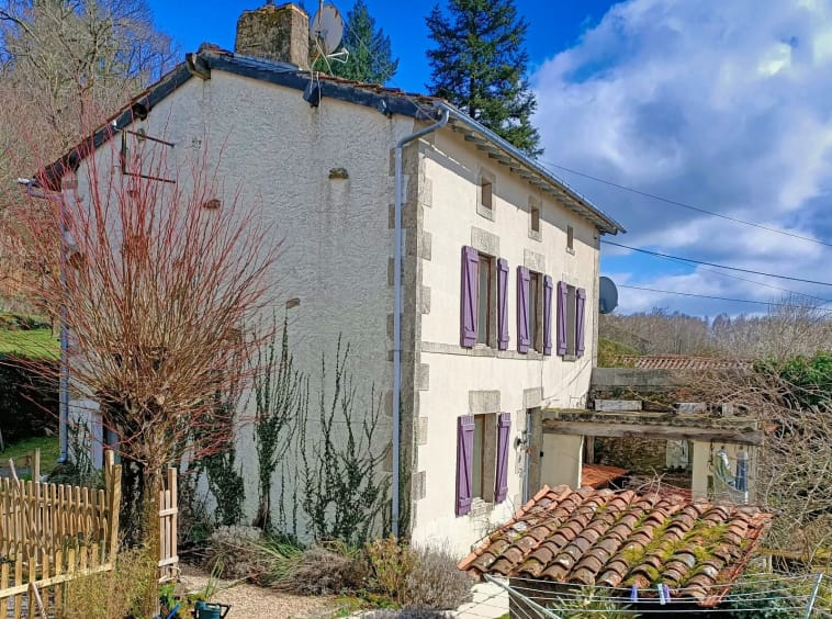 Charming countryside house with purple shutters.