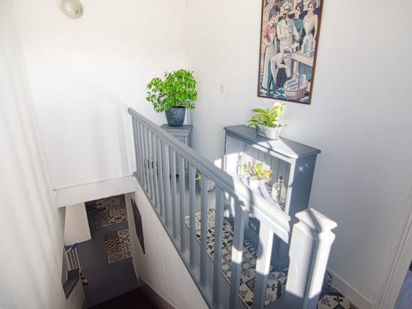 Bright staircase with potted plants and artwork.