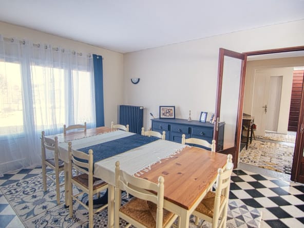 Spacious dining room with wooden table and large window.