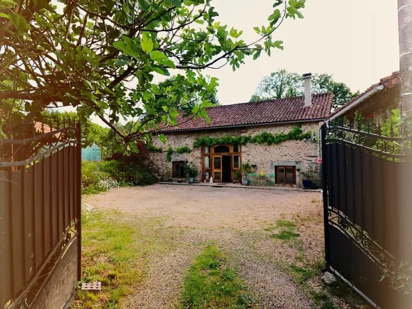 Charming country house with open gates and courtyard.