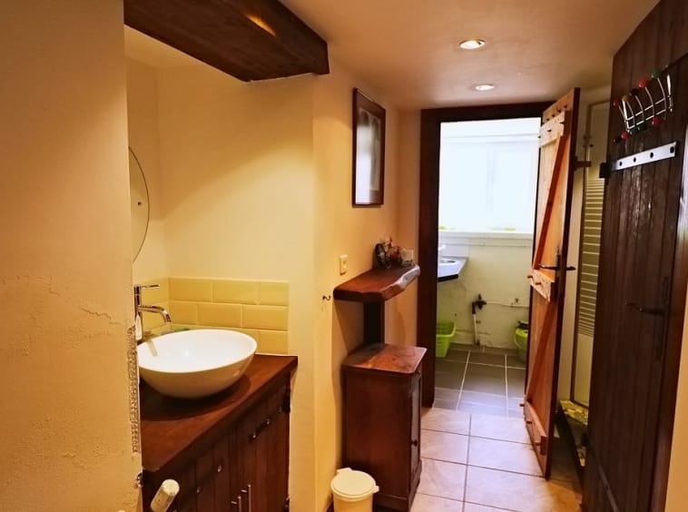 Rustic bathroom with basin, wood accents, open door.