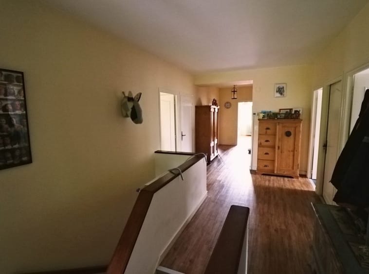 Hallway with wooden floor and furniture.