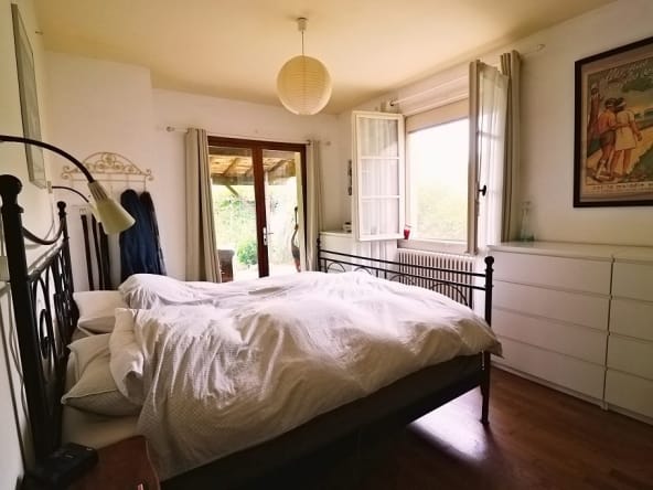 Cosy bedroom with large window and metal bed