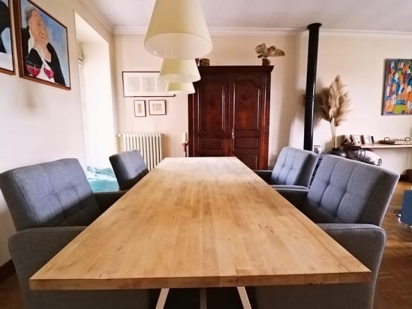 Modern dining room with wooden table and grey chairs.